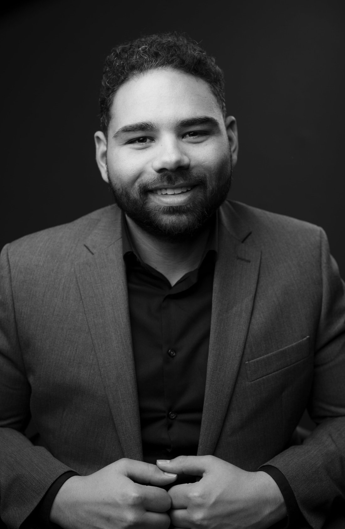 Devin Osborne, smiling, in a grey blazer